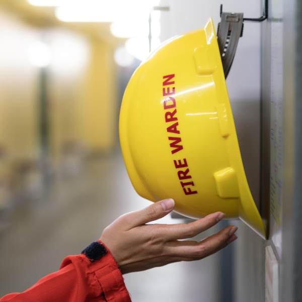 Fire Warden demonstrating vocational training on fire evacuation procedures as part of HSEQ compliance.